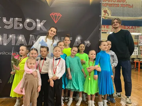 Младшие воспитанники клуба в разноцветных платьях с тренерами на «Кубке Диаманта»
